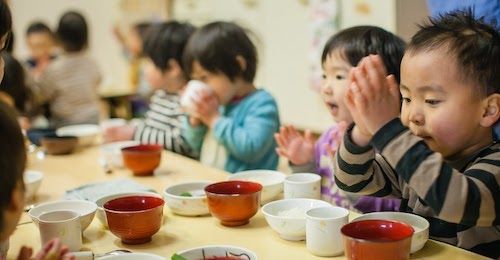 手作り給食を前にいただきますをする子どもたち