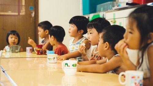 仲間と一緒に手作りおやつを食べる子どもたち