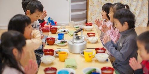 同じ食卓を囲んで手作り給食を食べる子どもたち