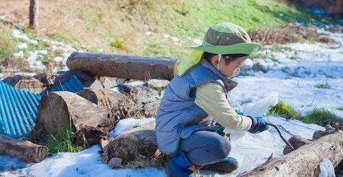 自然の水辺で夢中になって遊ぶ子ども