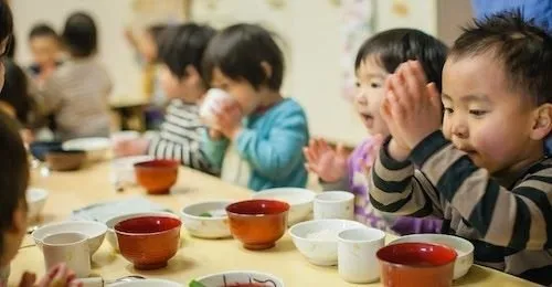 手作り給食を前にいただきますをする子どもたち
