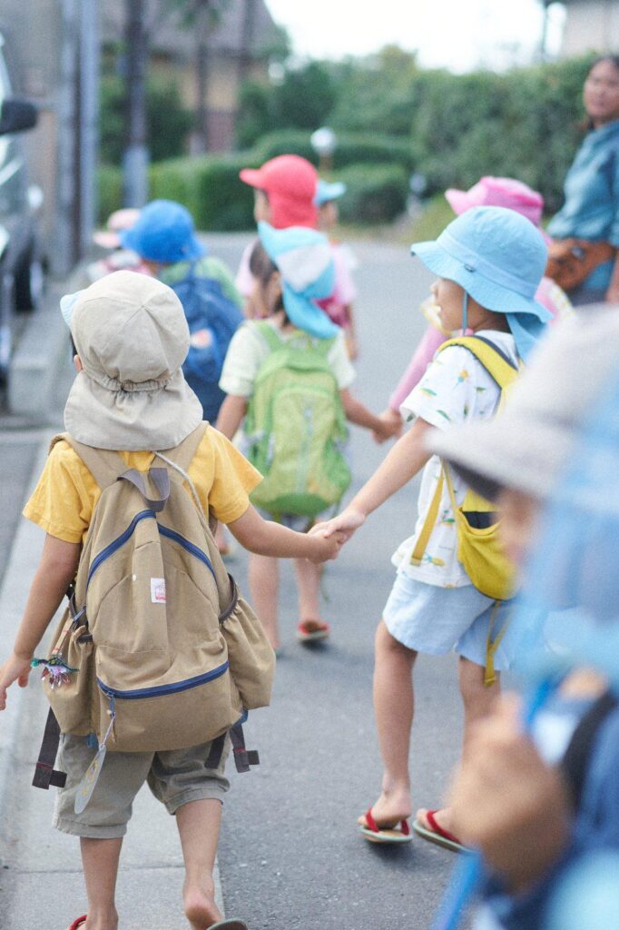 手をつないで散歩する子どもと保育者